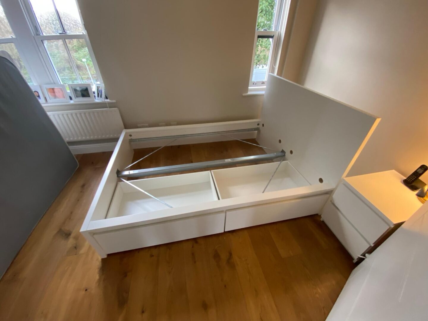 A bed frame with drawers in the middle of it.